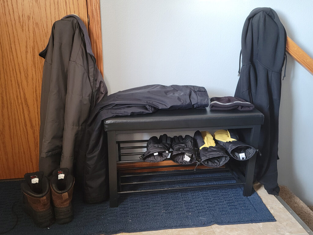 Snow clothes scattered around a bench.