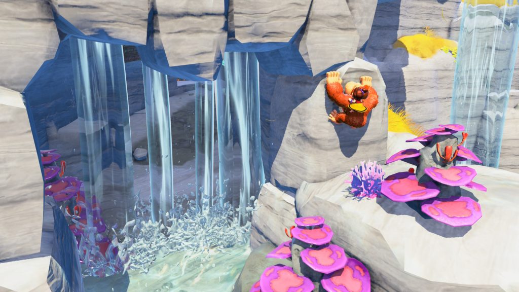 Donkey Kong climbing a rock wall next to a water fall.